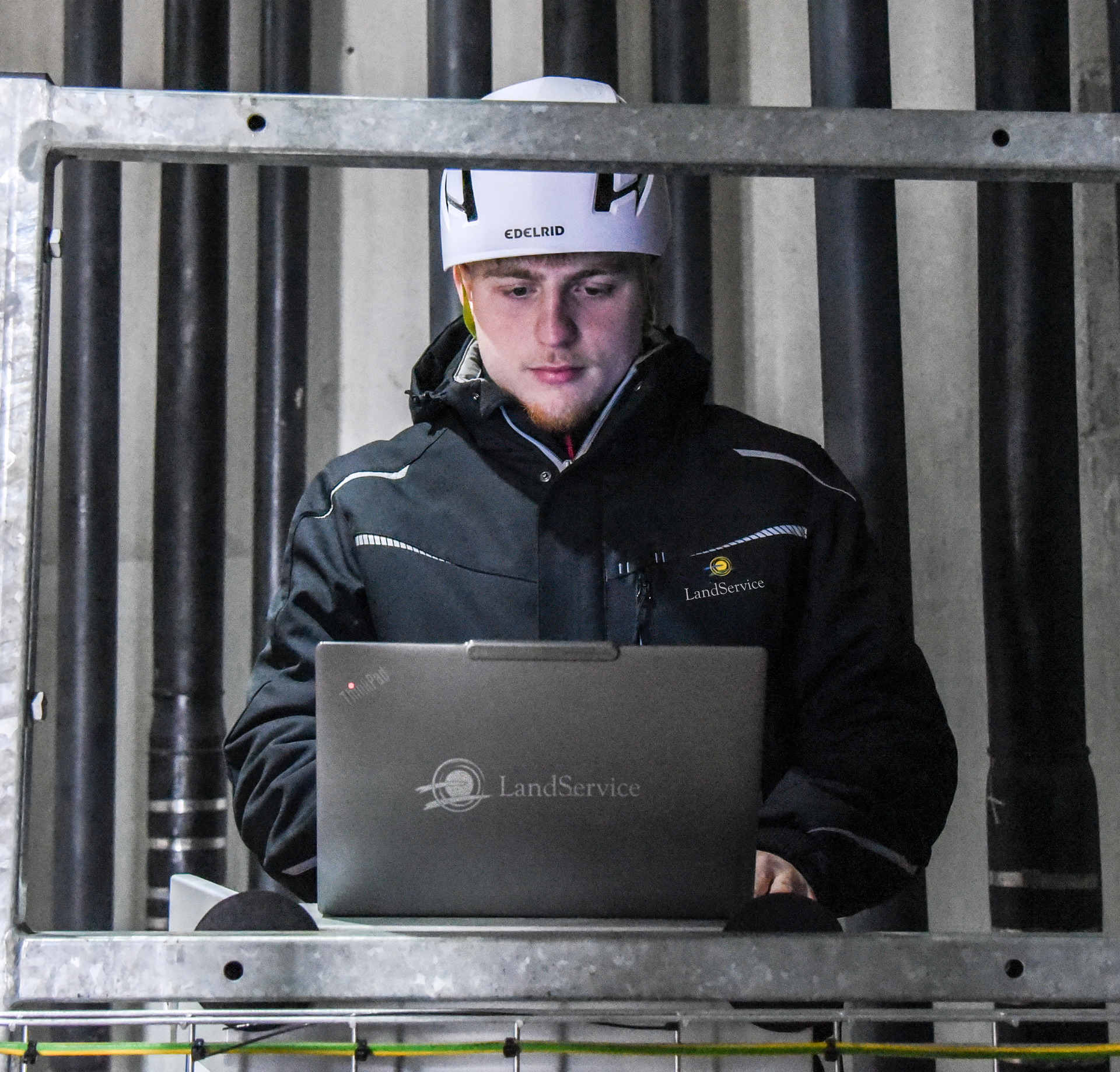 Mitarbeiter der LandService arbeitet mit Laptop an der IT-Technik im Inneren einer Windenergieanlage im Windpark Gevensleben